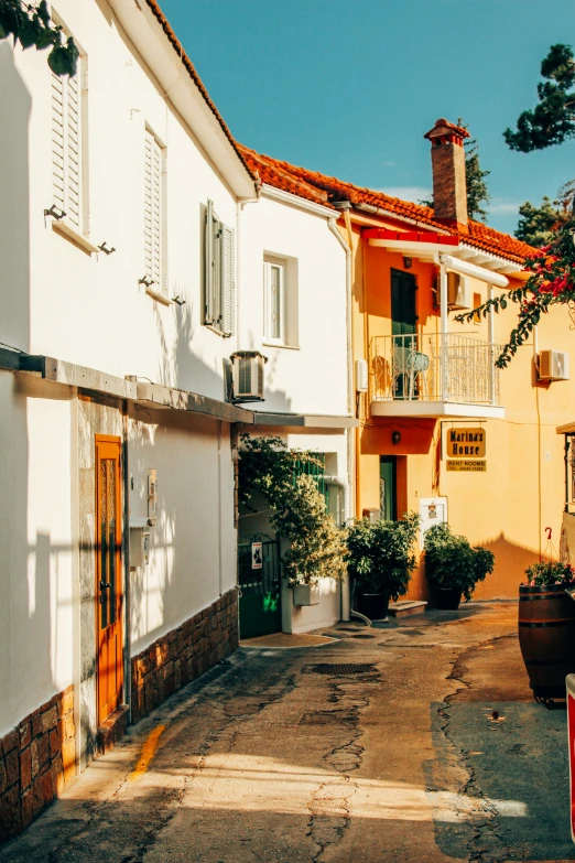 an empty street leading up to white and yellow building