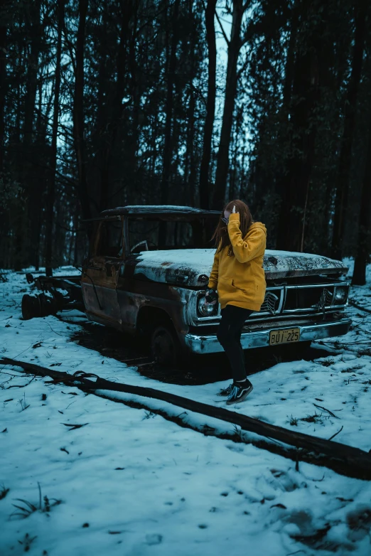 a woman sits on the ground beside a truck