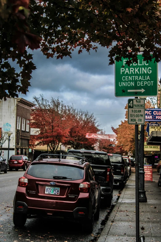 the street sign has a lot of cars parked on it