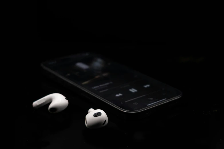 two earbuds laying next to an iphone on the table