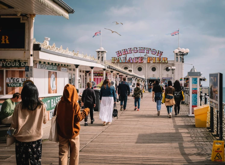 people walking on a boardwalk near an amut park