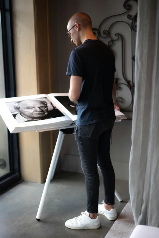 a man is standing over a table drawing with a drawing machine