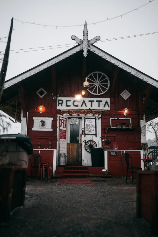 a large red barn that has a lighted door