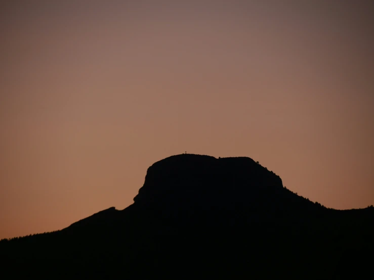 a large rock and the sky in silhouette