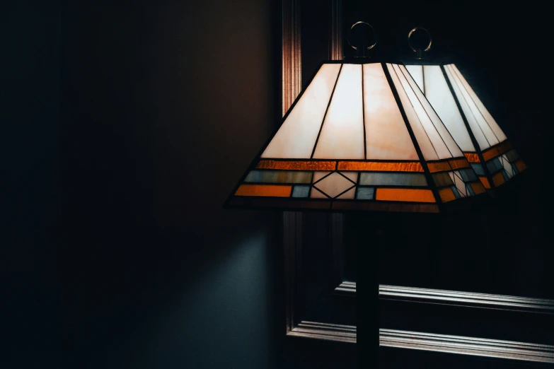 a lamp sitting next to a mirror with a brown lamp shade