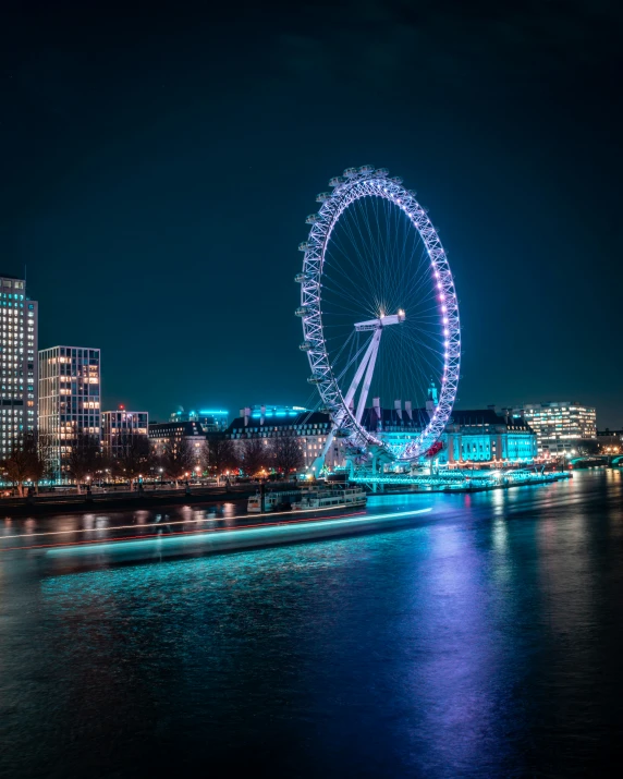 the ferris wheel lights up in the dark sky