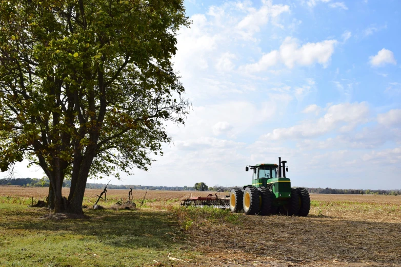 a tractor is parked next to a tree