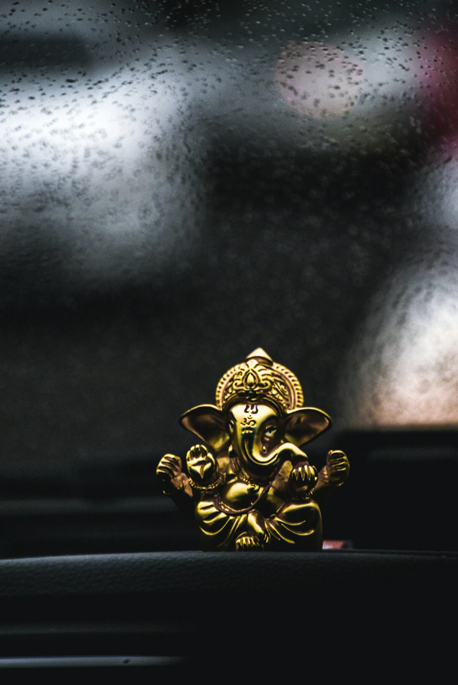 the golden statue of a god on the dashboard of the car