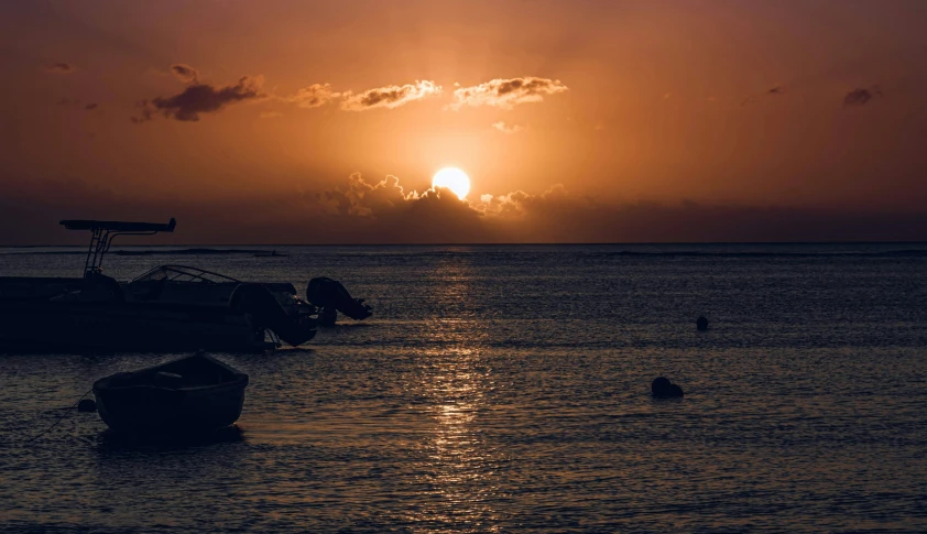 boats are in the water with the sun setting