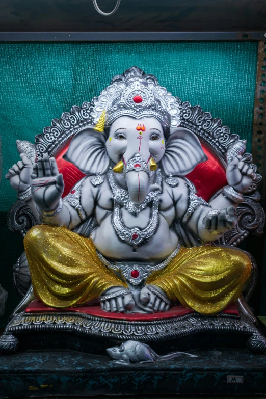 statue of lord ganesh on display in ornate gold, red, and silver temple