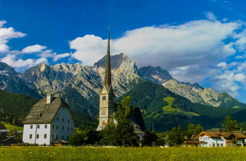 a village nestled between mountains with the town's steeple visible