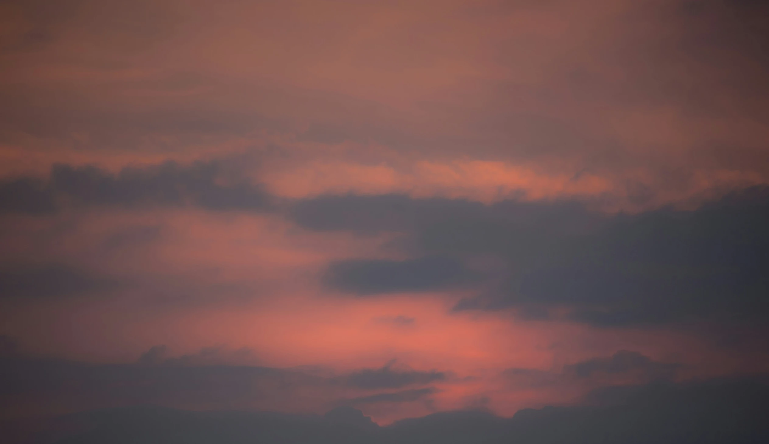 a jet flying through a dark sky covered in clouds