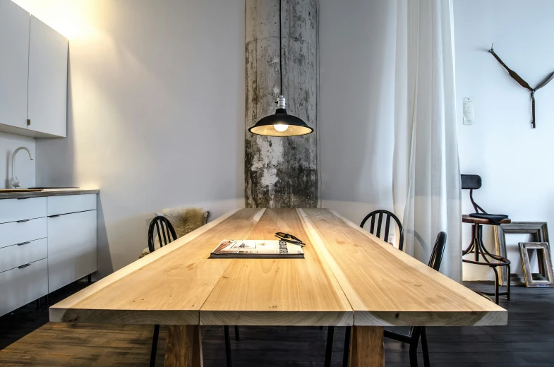 wooden table next to four chairs in a kitchen