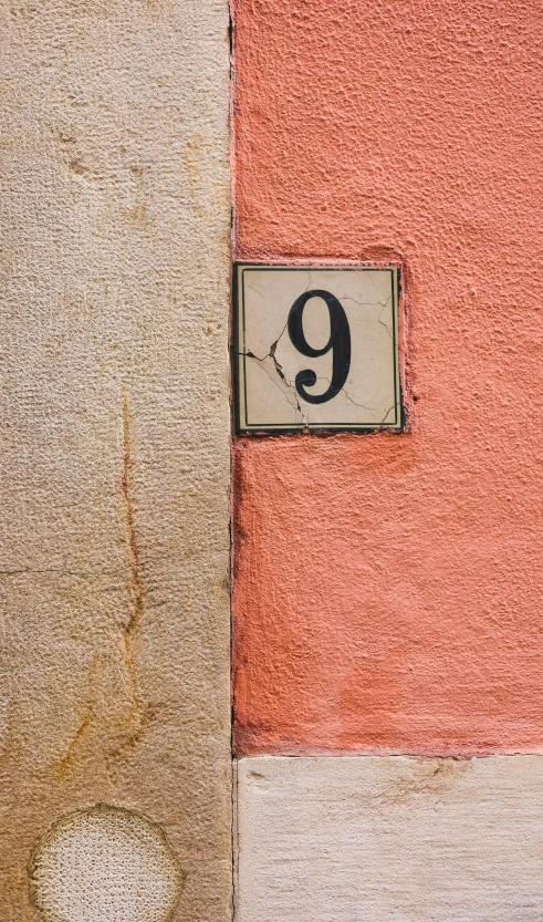 a number nine sign is placed next to a brown and red wall