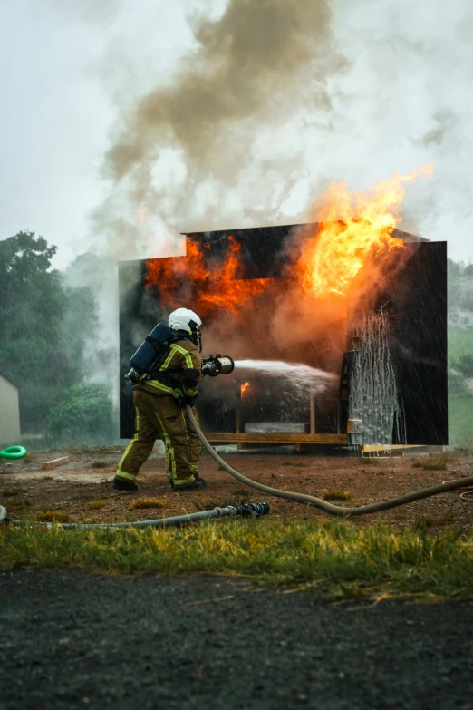 a firefighter putting out a blaze at a truck