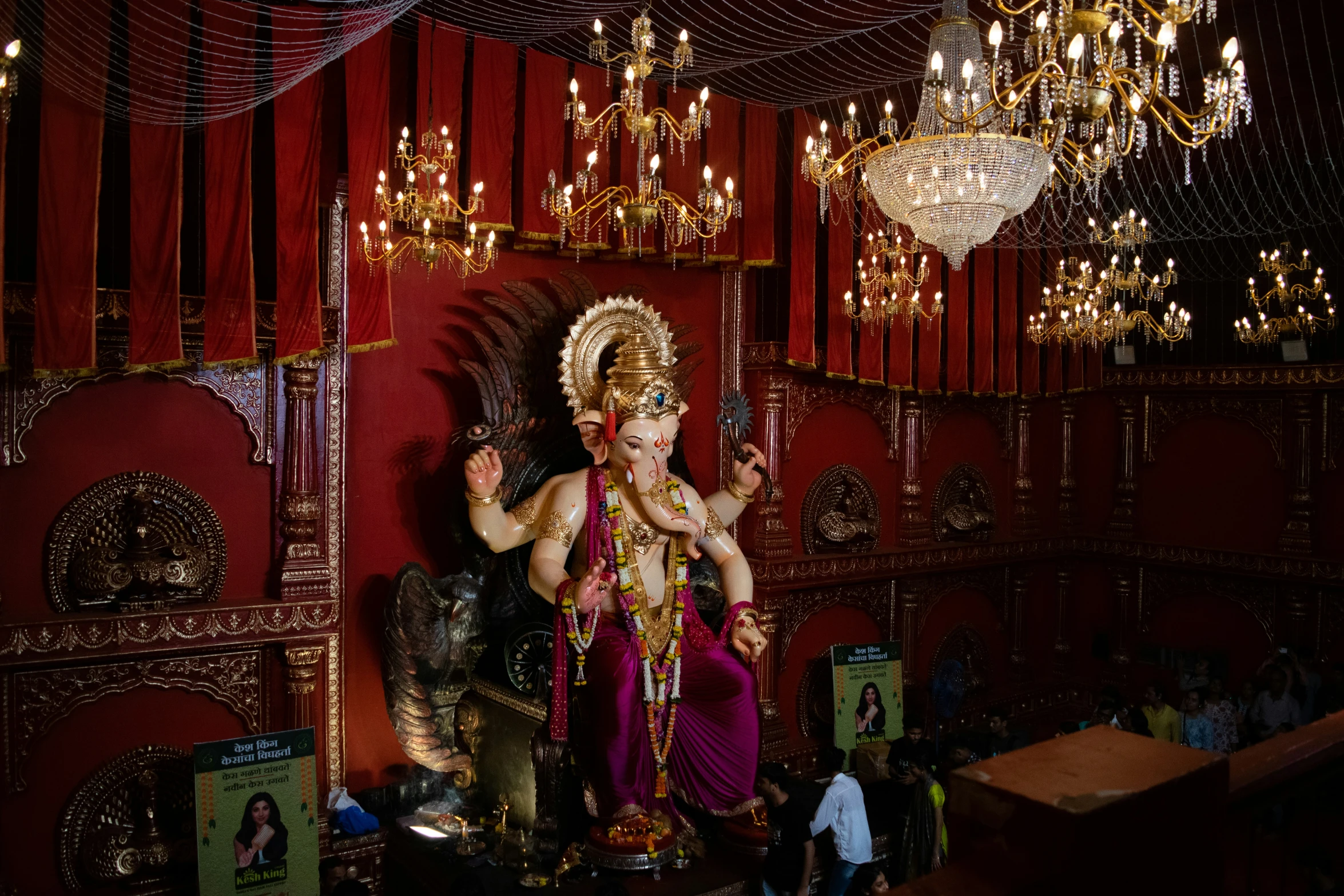 a statue of an indian god in front of a chandelier