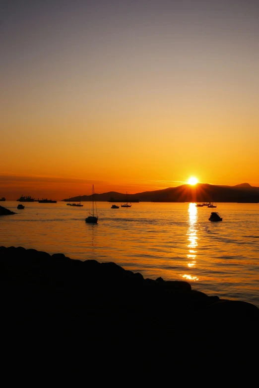 boats floating on a body of water at sunset