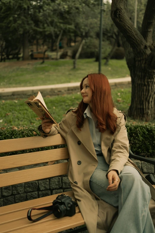 a woman sits on a bench reading a book