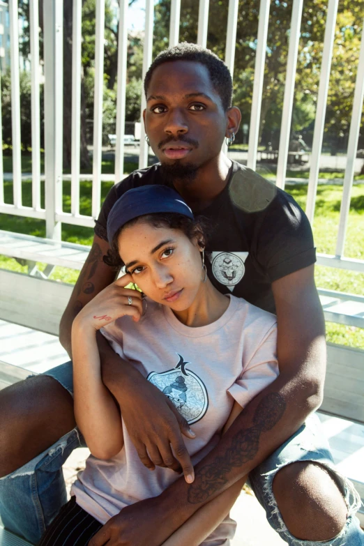 a man and a woman sitting together and looking at the camera