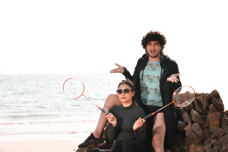 two guys sitting on a pile of rocks and some net