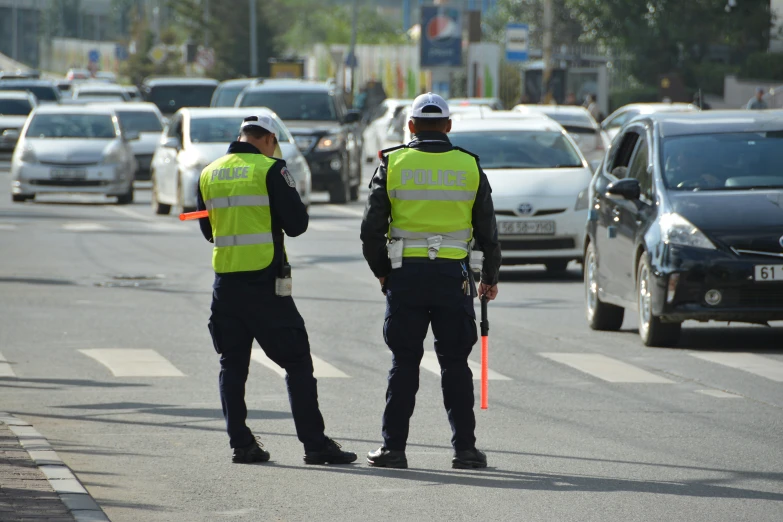 two police officers are on the side of the road