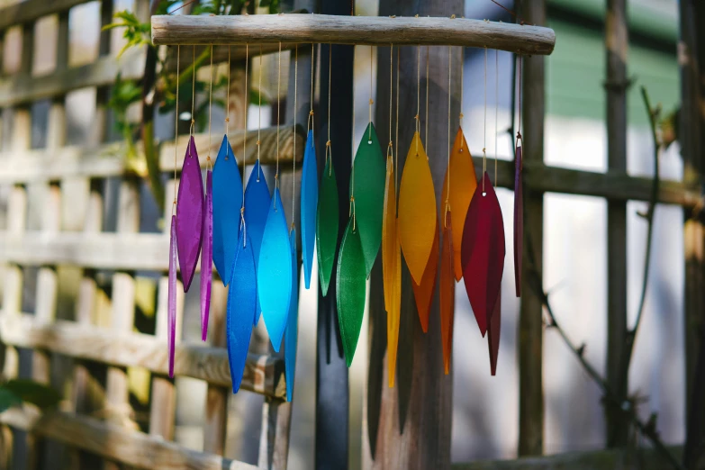 colorful wind chime displayed on wooden fence