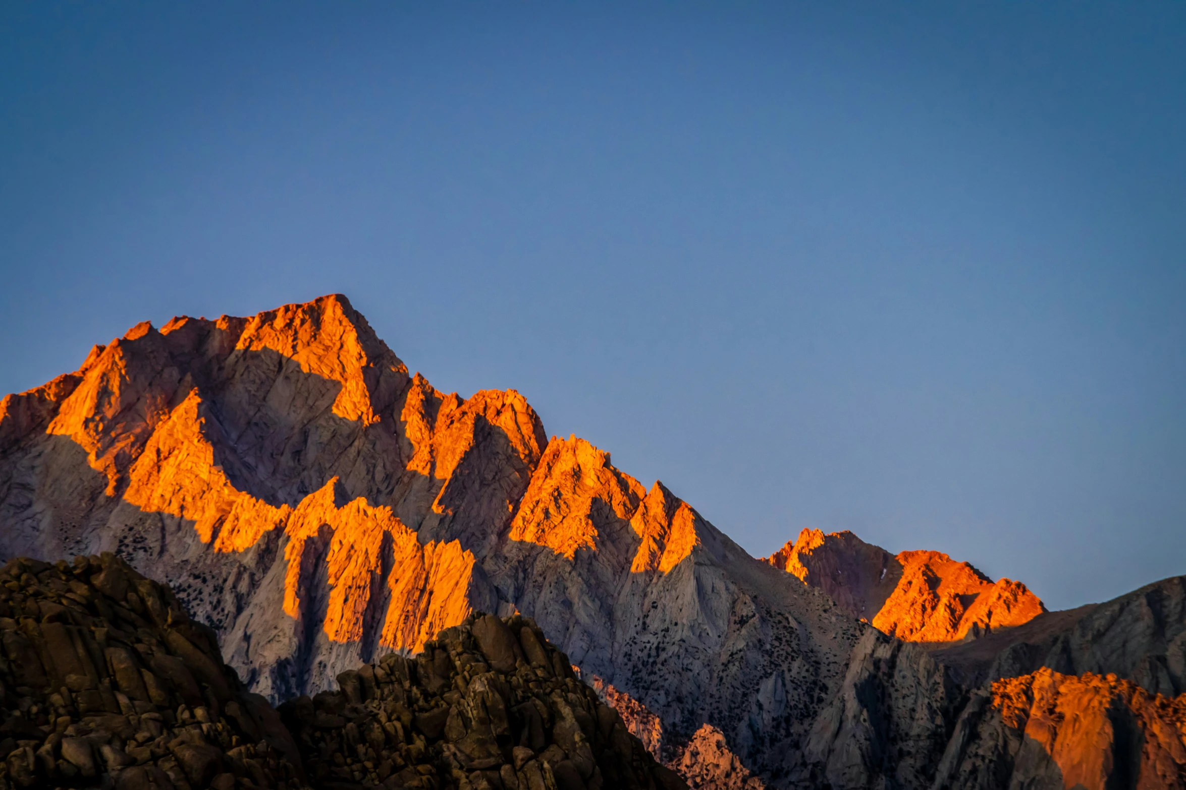 the view of a mountain range and its snow capped peaks