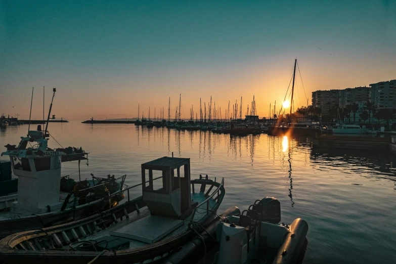 many boats are in the water as the sun sets