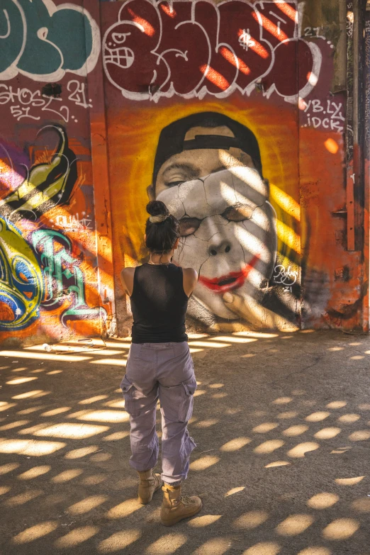 a woman painting the walls with graffiti of a face