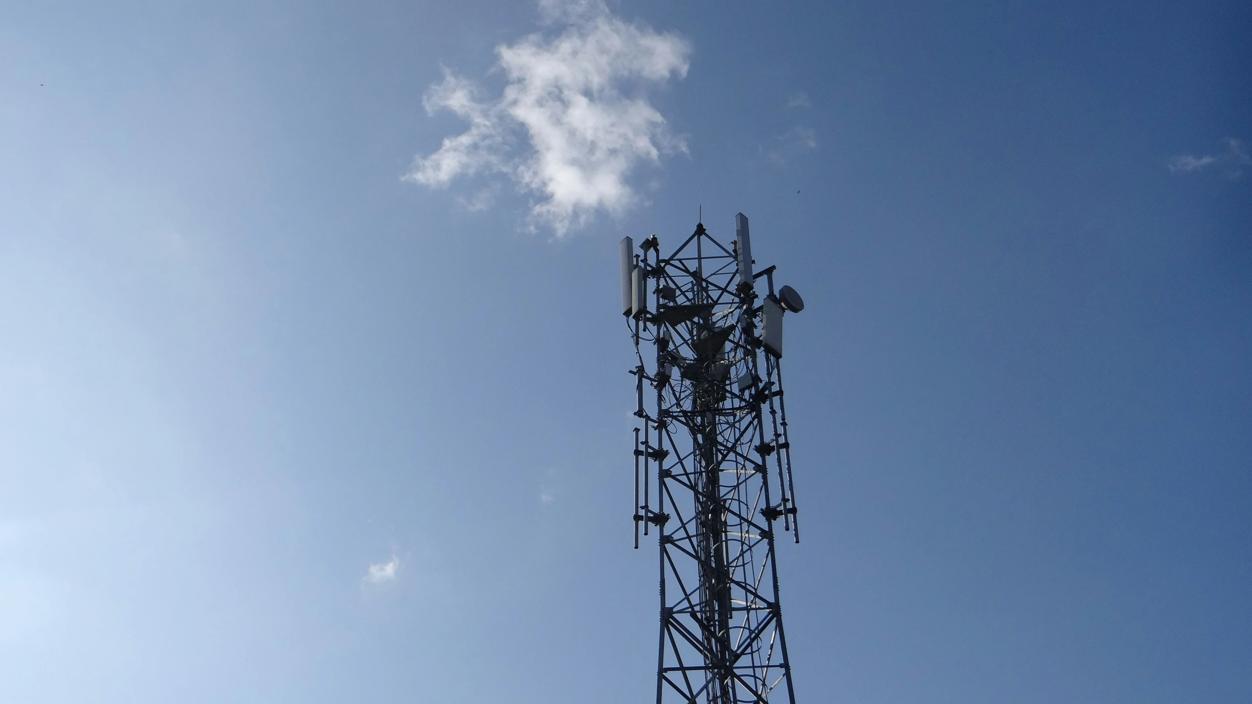 a cell phone tower against the blue sky