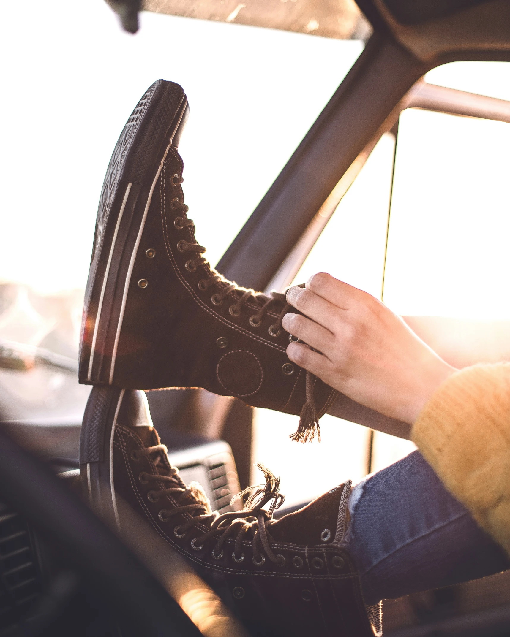 the person's feet on the seat of a vehicle