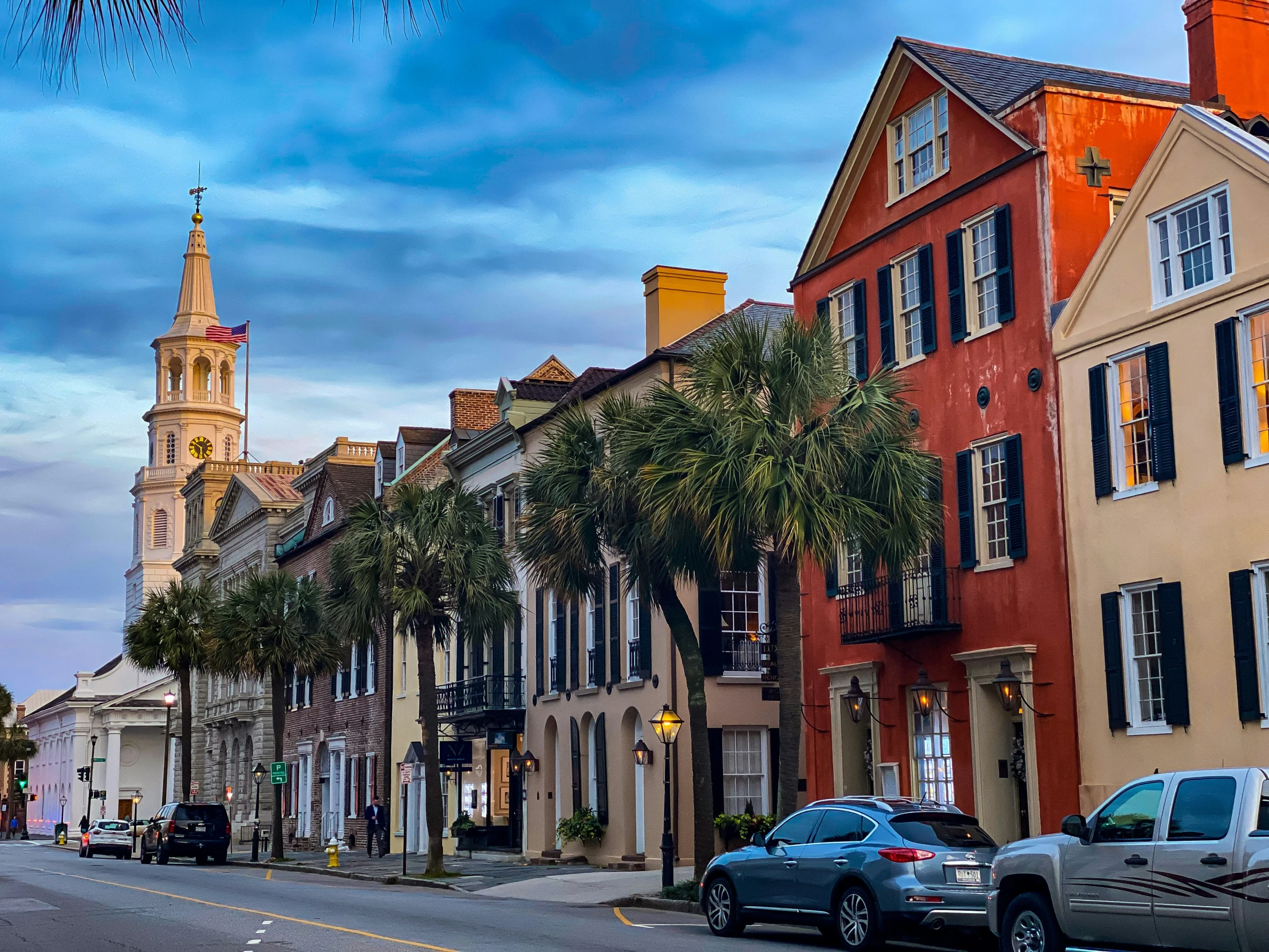 a city street with colorful buildings and palm trees