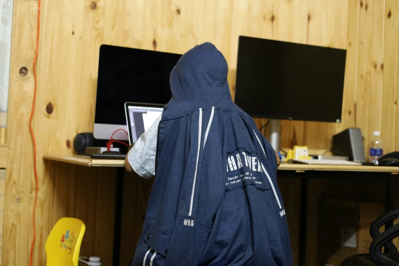 a man in black jacket using a computer on a desk