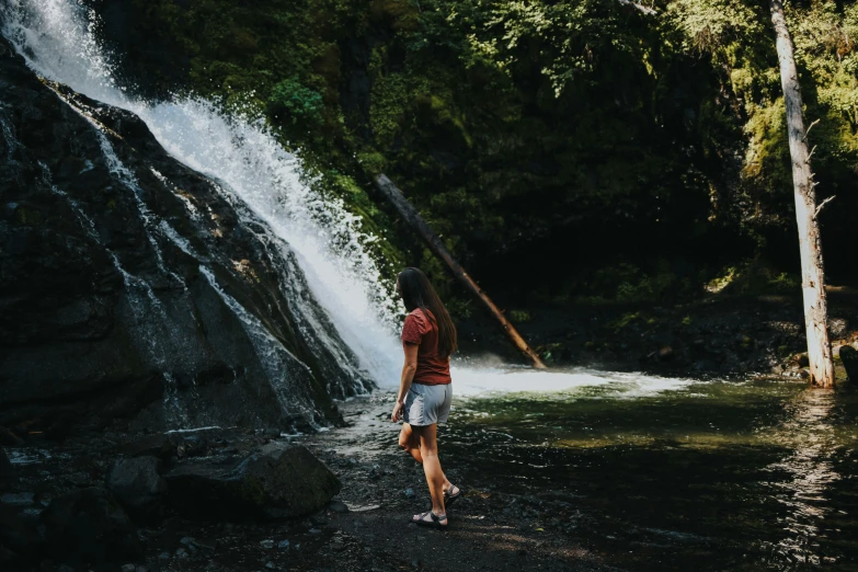 there is a woman that is by the waterfall