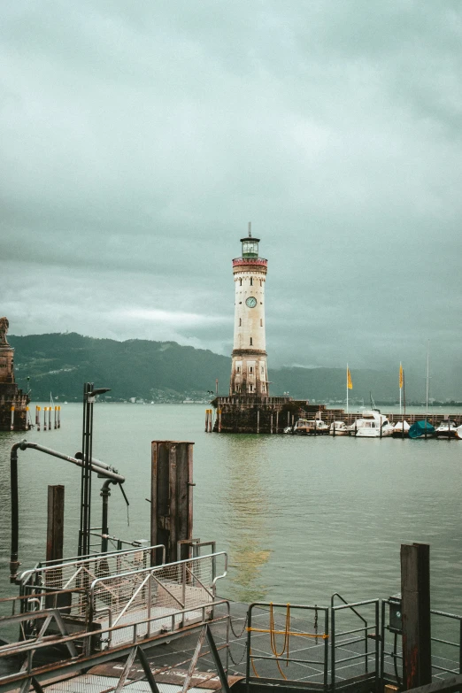 an image of a clock tower sitting at the end of a dock