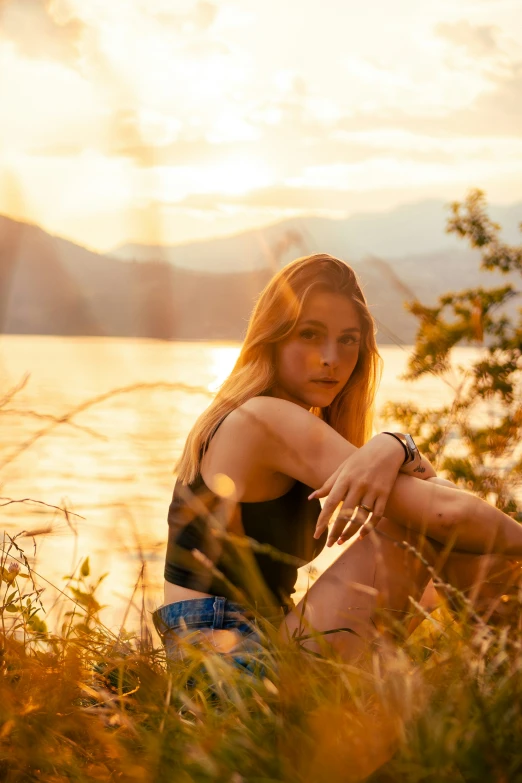 a girl is posing for a po next to the water