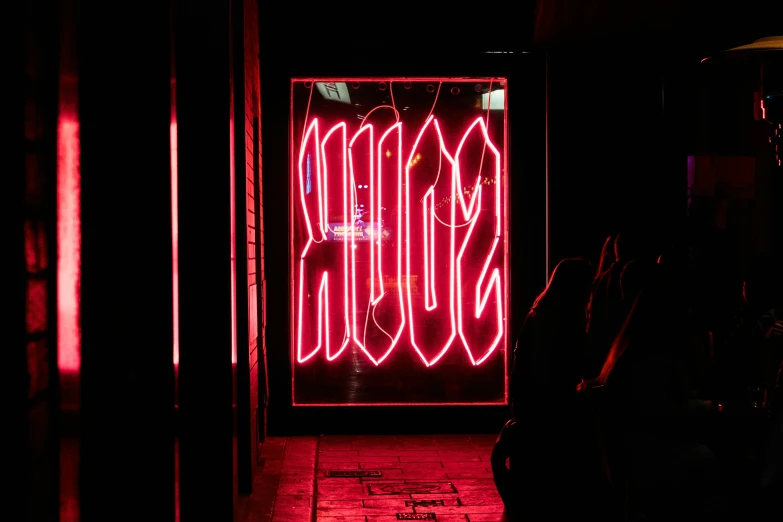 a red neon sign that is outside of a building