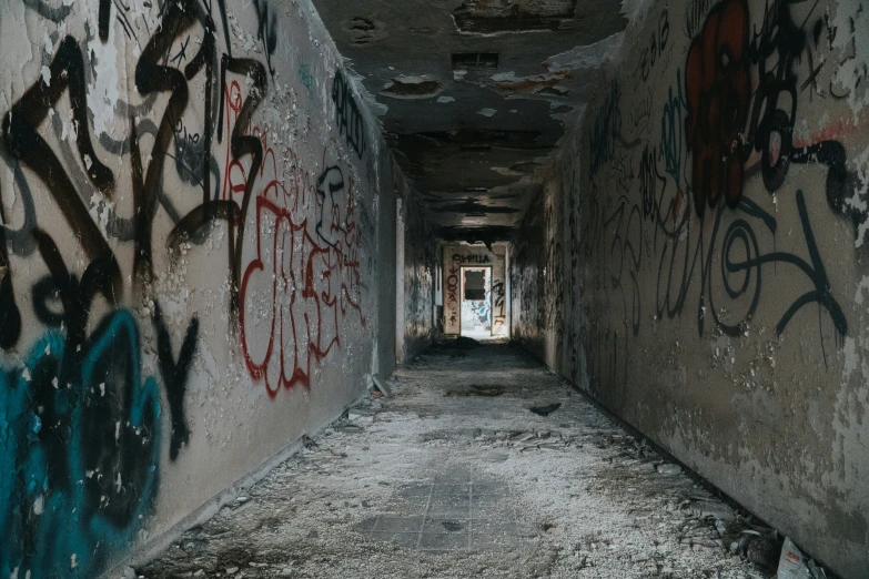 a long hallway covered in graffiti and spray paint