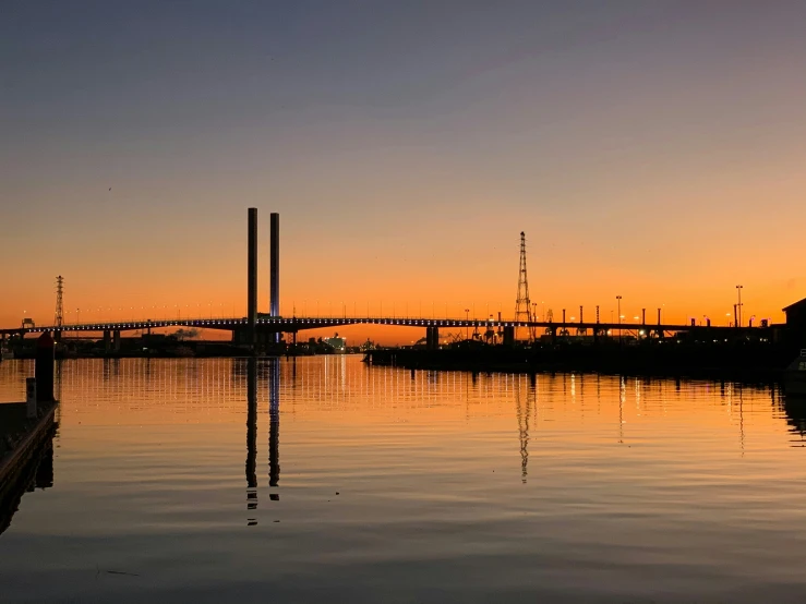 some boats on the water at sunset and a bridge