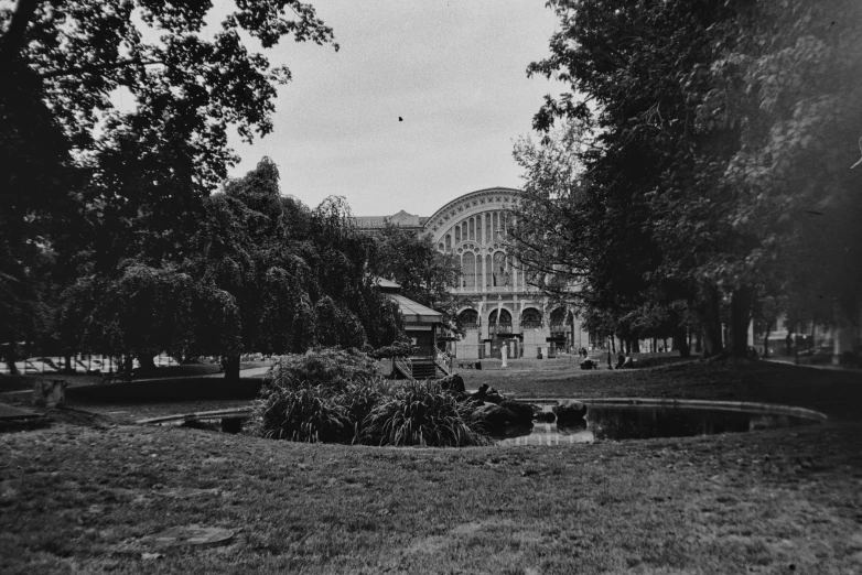 an old fashioned po of a very large building in the trees