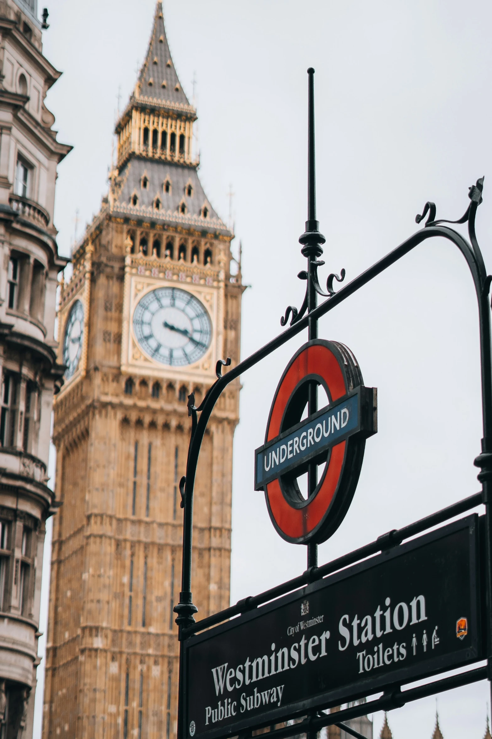 there is a clock and street sign next to the building