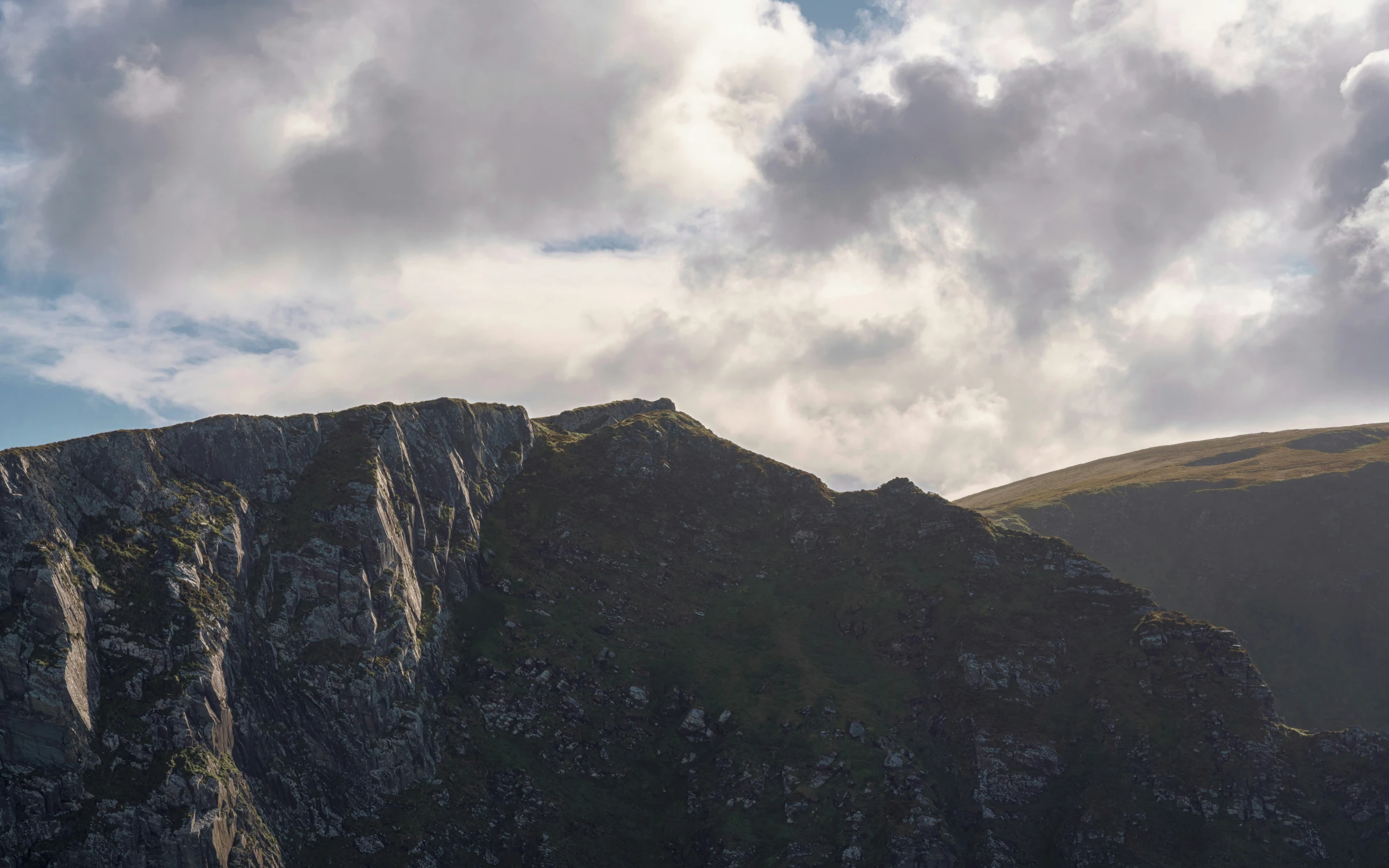 a view of a mountain top in a green setting