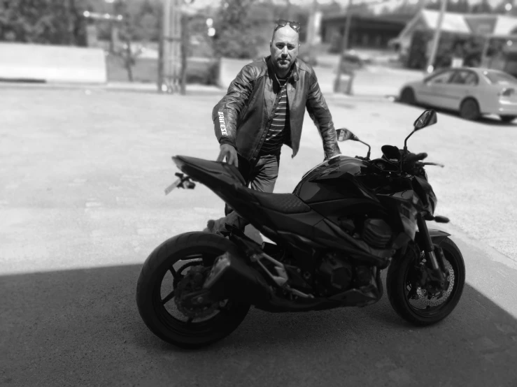 a man in full leather clothes and glasses standing next to a motorcycle