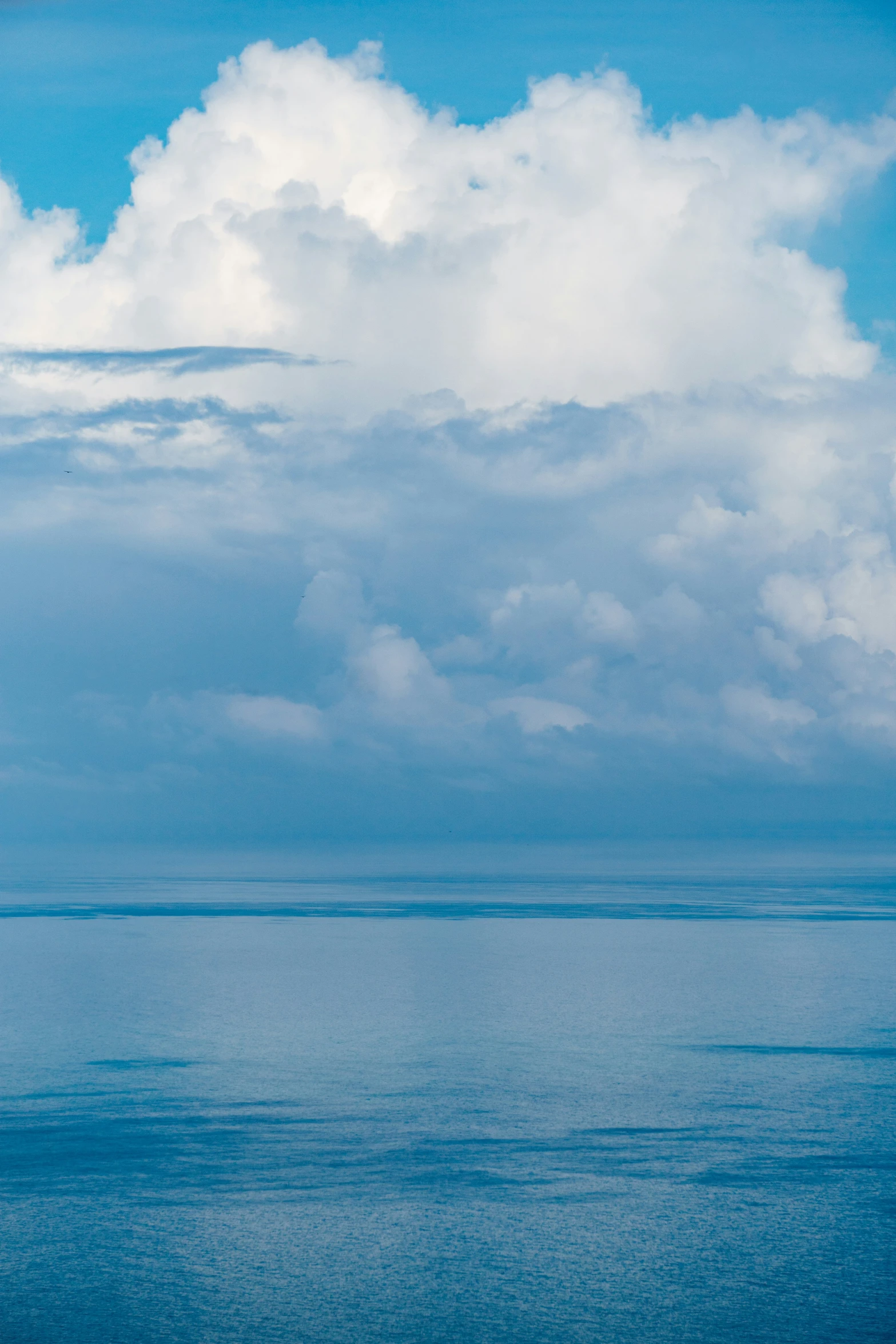 a big blue sky with a very thin white cloud