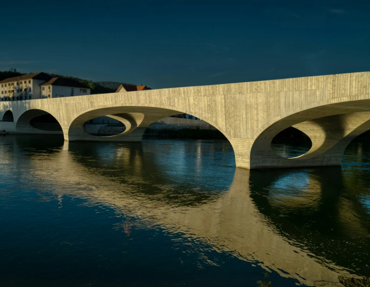 a stone bridge spans over a river in the town