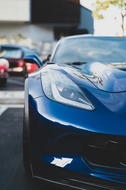 the front view of a blue chevrolet corvette on a street