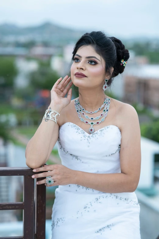 a bride in a white dress poses in the rain