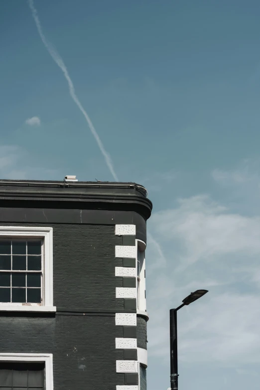 a po of a building with a plane contrail above it