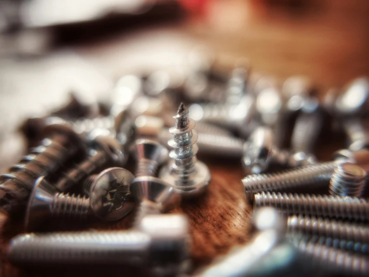 a wooden table with a bunch of screws on it