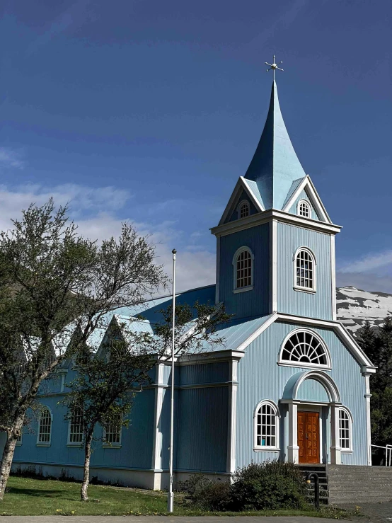 a blue church stands alone in the winter